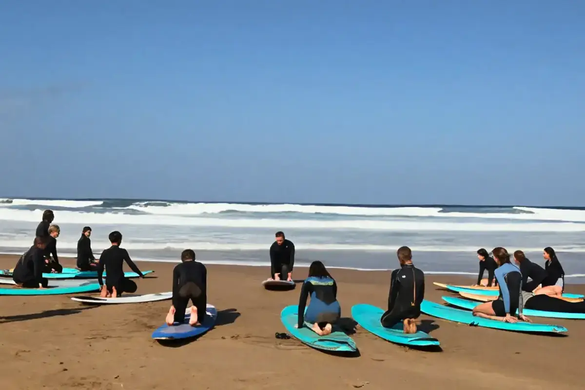 le cours de surf sur le sable, face aux vagues